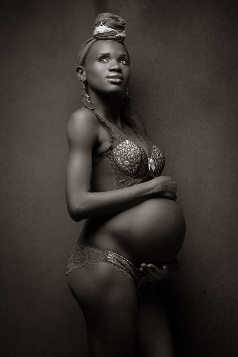 Fotoshooting einer schwangeren dunkelhäutigen Frau, die stolz ihren Babybauch zeigt