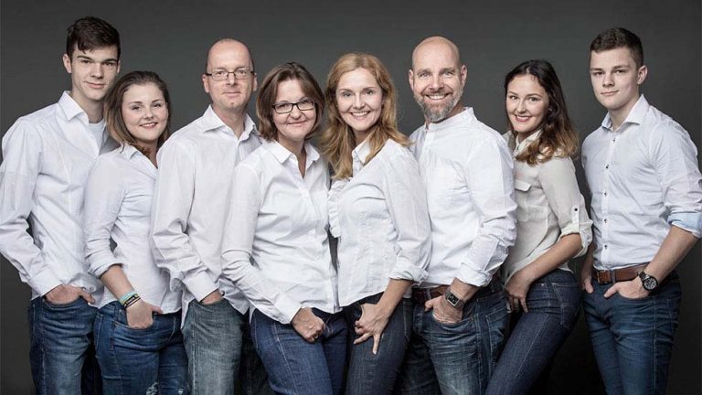 Familienfoto in Jeans und weißen Hemden von zwei Familien. Die Eltern mit Ihren erwachsenen Töchtern und Söhnen.