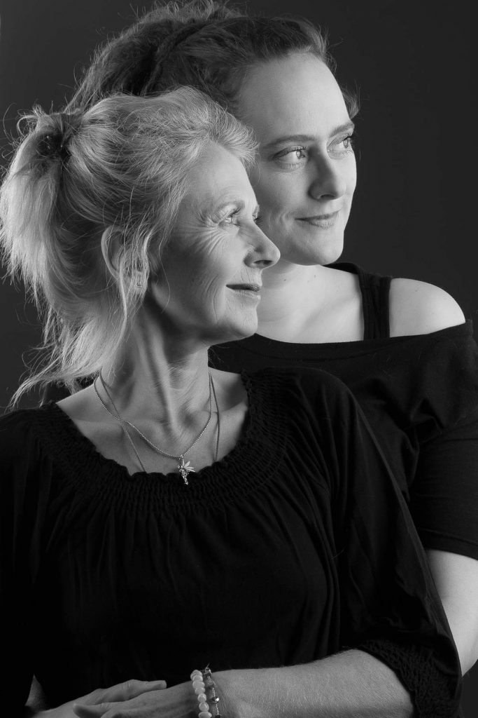Schwarz-Weiß Foto von einer lächelnden Mutter mit ihrer erwachsenen Tochter
