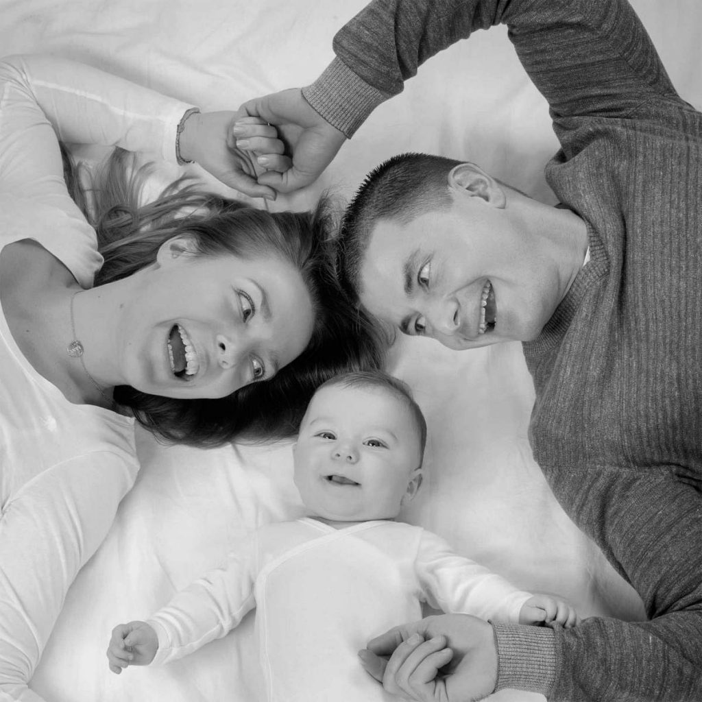 Schwarz-Weiß Foto von lachenden Eltern und Ihrem Baby