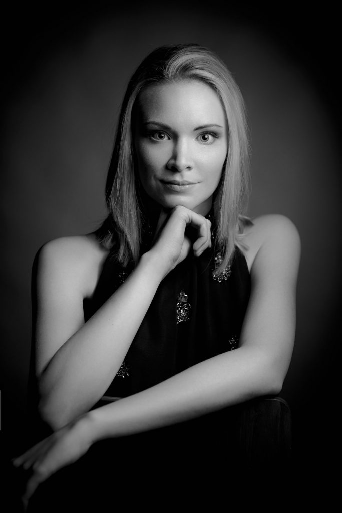 Schwarz-Weiß Studio Portraitfoto einer Frau, die ihren Kopf auf die Hand stützt